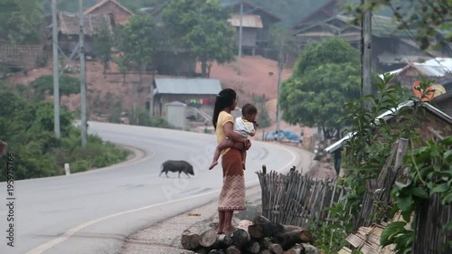 A Woman With A Child On The Lao Village Street
