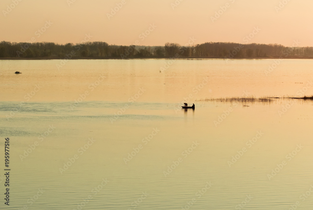 Fishermen in a rowing boat swim early in the spring on fishing on the Volga River