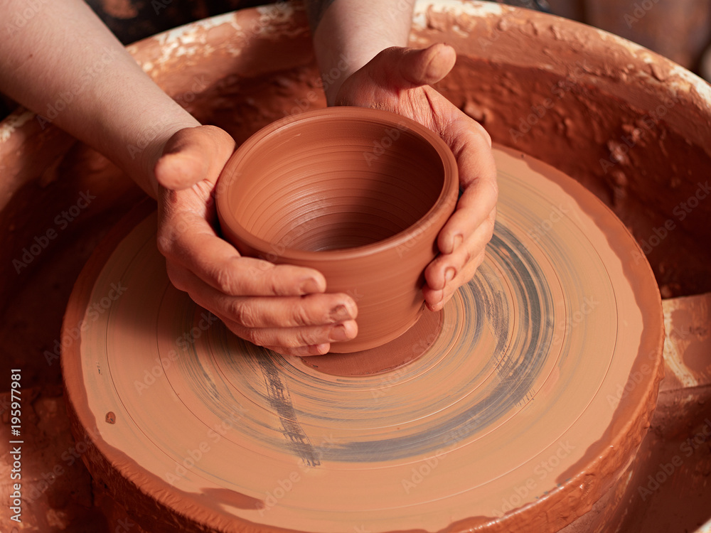 production process of pottery. A cut of a clay cup from a potter's wheel. production process of pottery. A cut of a clay cup from a potter's wheel.
