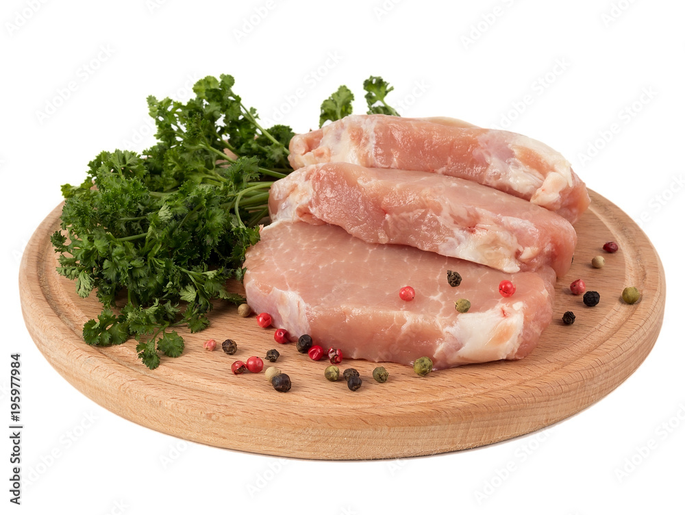Three pieces of pork on a board with parsley and pepper