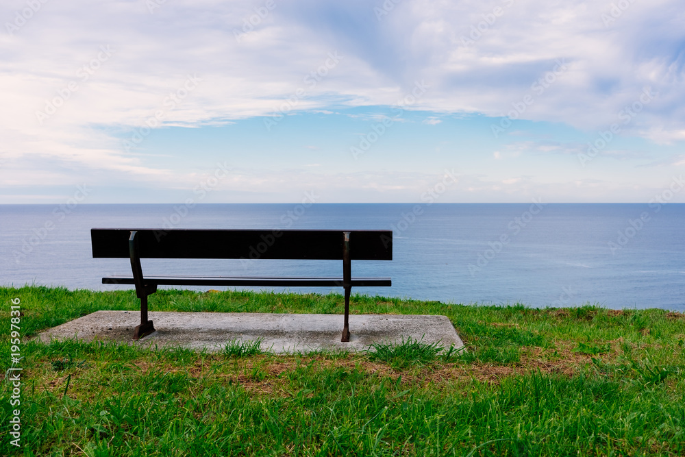 Empty wooden bench with a viewpoint looking out to sea
