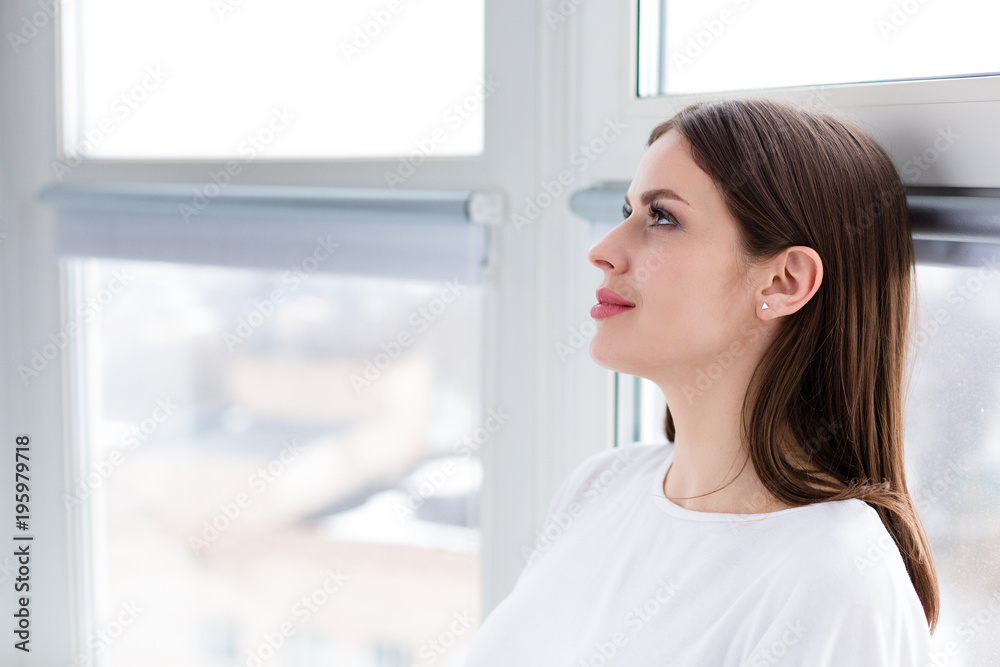 Beautiful happy woman sitting by the window