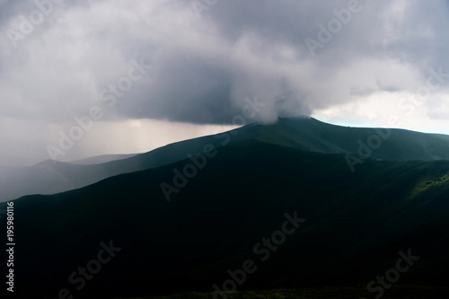 Storm rainy clouds above mountains. Apocalypse fantasy fabulous sky. Beautiful windy dramatic cloudscape at nature. Picturesque scenic view outdoor. Travel in wild territory. Discover rocky hills.