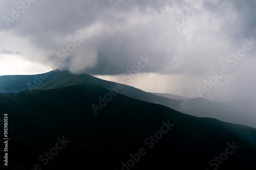 Storm rainy clouds above mountains. Apocalypse fantasy fabulous sky. Beautiful windy dramatic cloudscape at nature. Picturesque scenic view outdoor. Travel in wild territory. Discover rocky hills.