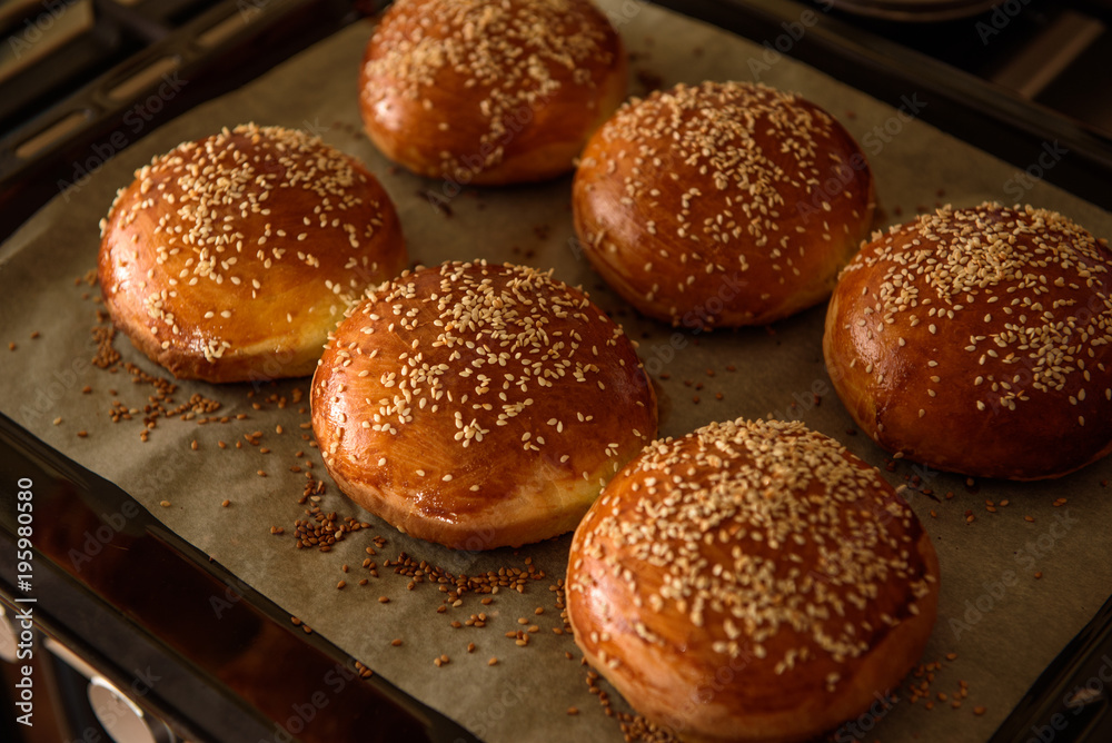 homemade burger rolls sprinkled with sesame seeds are baked in the oven homemade burger rolls sprinkled with sesame seeds are baked in the oven