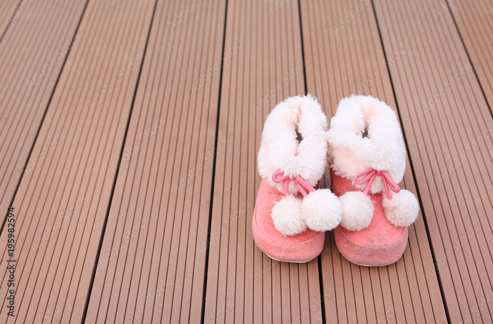 Pair of baby fashion shoe on wood plank background with copy space. Shoes for winter season. Pair of baby fashion shoe on wood plank background with copy space. Shoes for winter season.