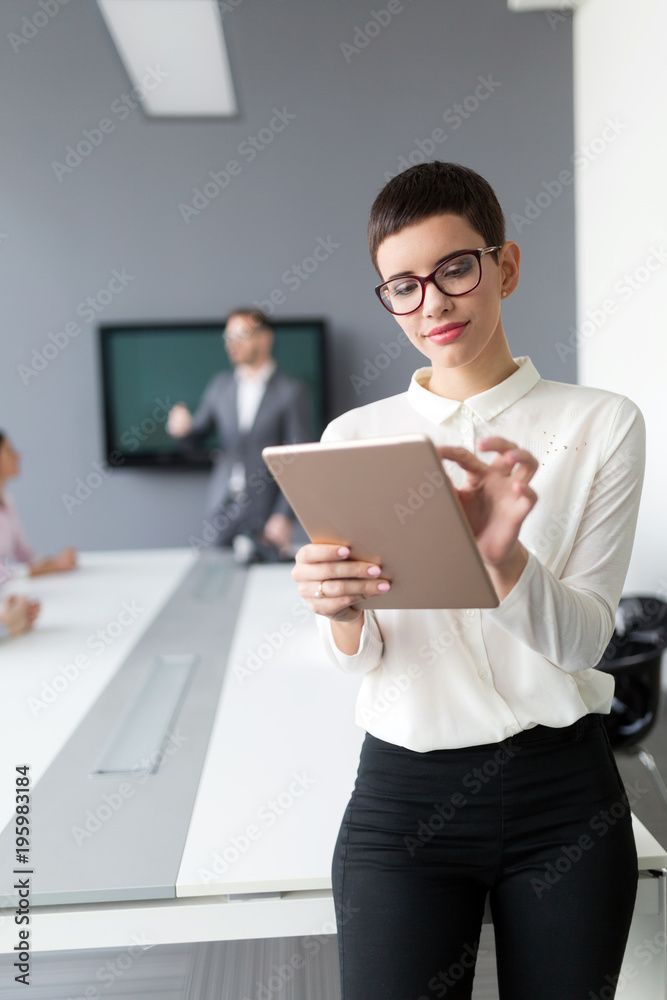 Beautiful businesswoman holding tablet in office Beautiful businesswoman holding tablet in office