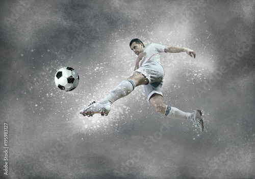 Football player with ball in action under sky with clouds © Andrii IURLOV