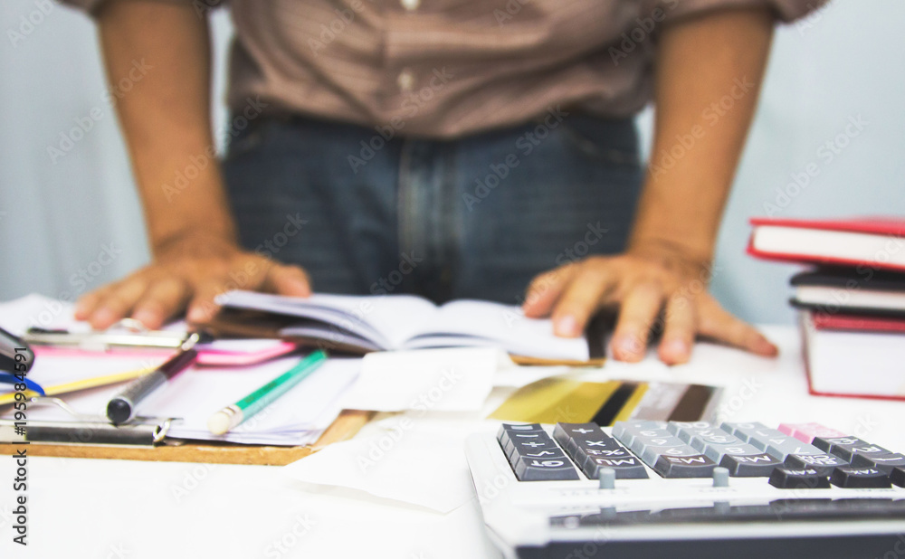 businessman using calculator and holding pen on tax paper in office.Accounting.concept. businessman using calculator and holding pen on tax paper in office.Accounting.concept.