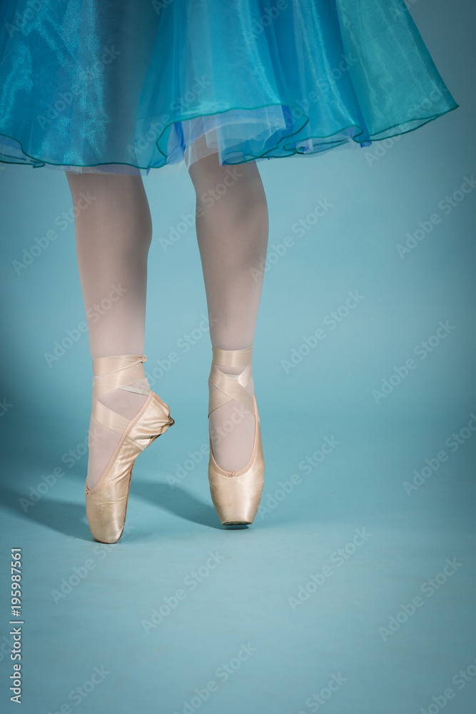 feet of the ballerina in toe shoes on the turquoise background feet of the ballerina in toe shoes on the turquoise background
