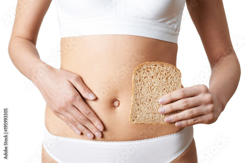 Close Up Of Woman Wearing Underwear Holding Slice Of Brown Bread And Touching Stomach