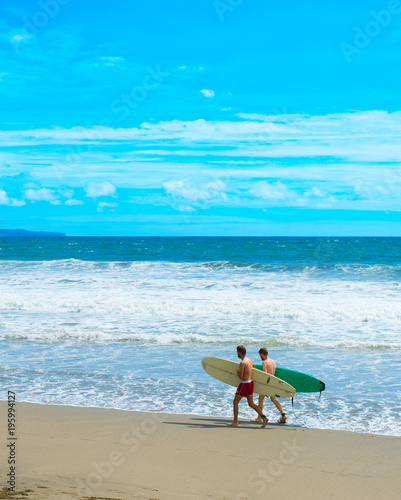 Fototapeta Naklejka Na Ścianę i Meble -  Two surfers on ocean beach