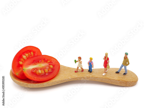 Miniature children standing on fresh grape or cherry tomato with wooden spoon, thinking of healthy, nutrient and clean food. Healthy lifestyle concept. white background.
