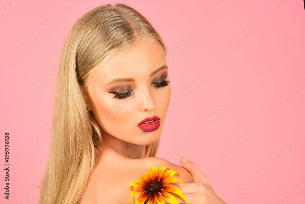 Skincare, beauty, skin health concept - gorgeous blonde girl with perfect makeup, flower on shoulder. Attractive sexy blonde woman with long hair bright makeup holds flower. Copy space for advertise. Skincare, beauty, skin health concept - gorgeous blonde girl with perfect makeup, flower on shoulder. Attractive sexy blonde woman with long hair bright makeup holds flower. Copy space for advertise.