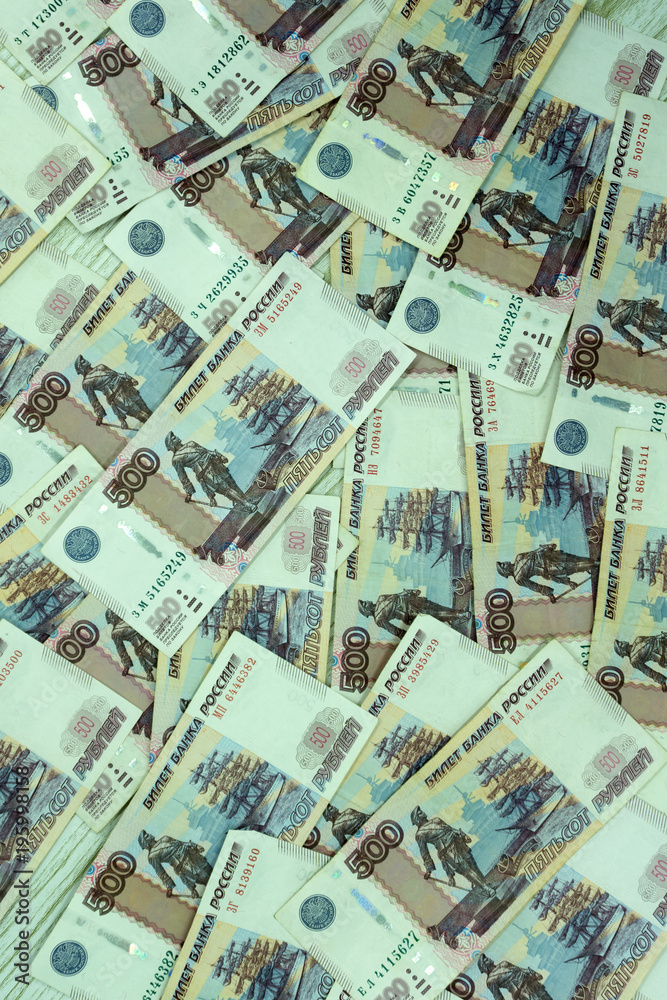 A pack of five rouble banknotes in half a million Russian rubles in a Bank package is on the background of disparate banknotes .