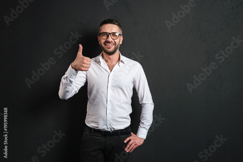 Cheerful businessman showing thumbs up.