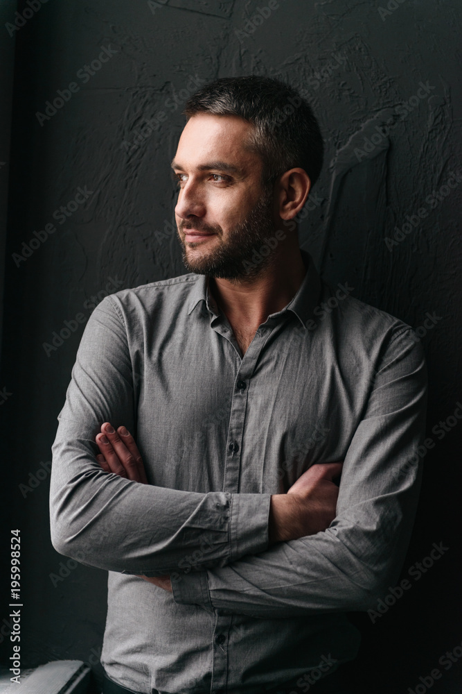 Handsome man standing over dark background Handsome man standing over dark background