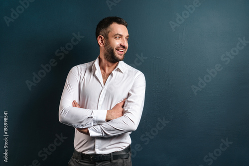 Handsome cheerful man standing over dark blue background
