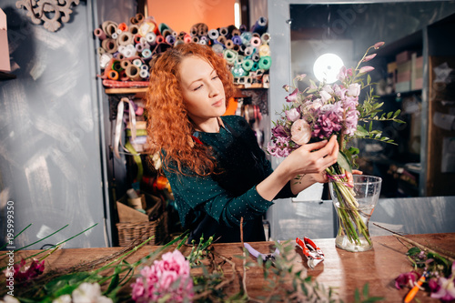 Fotografi image of young Caucasian hardworking flower asistant concentrating on her work,