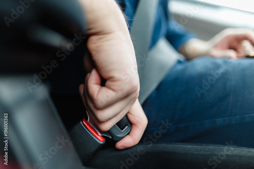 Wallpaper Mural Men's hand fastens the seat belt of the car. Close your car seat belt while sitting inside the car before driving and take a safe journey. Closeup shot of male driver fastens seat belt. Torontodigital.ca