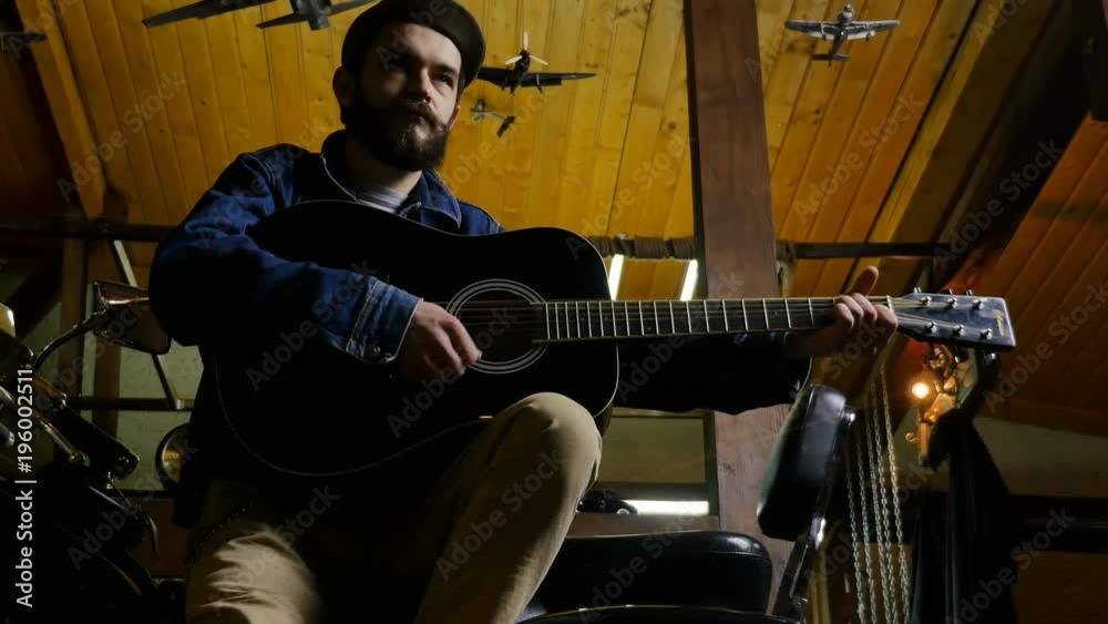 Handsome bearded musician playing guitar in the pub Handsome bearded musician playing guitar in the pub
