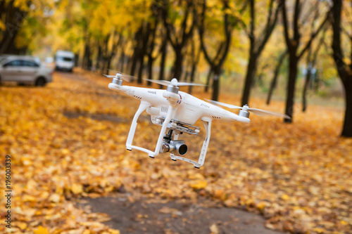 Dron with a video camera in the autumn park