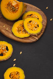 Delicious fresh pieces of ripe pumpkin on wooden background