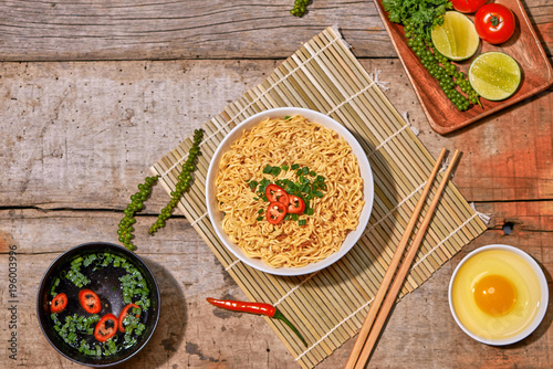 Vászonkép instant noodles in bowl with vegetable on wooden table.