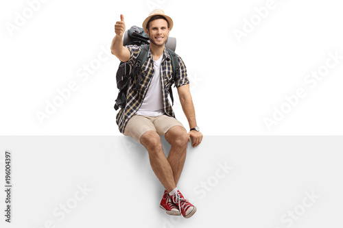 Photography Tourist sitting on a panel and making a thumb up gesture
