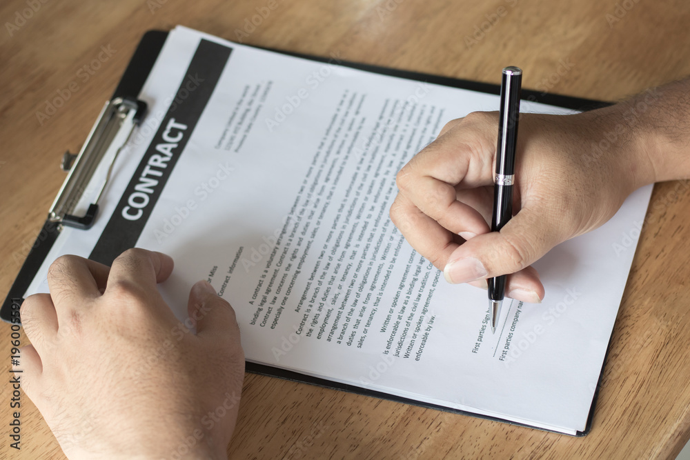 Businessman signing on contract paper on table after accepted deal and agreement . Businessman signing on contract paper on table after accepted deal and agreement .