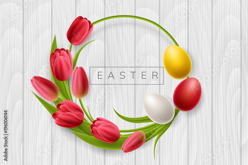 Round Easter frame from red tulip flowers and colorful Easter eggs. Circle frame on white wood texture for spring and Easter holiday design