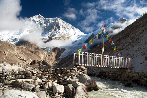 Mount Makalu with clouds, vooden bridge and river photo