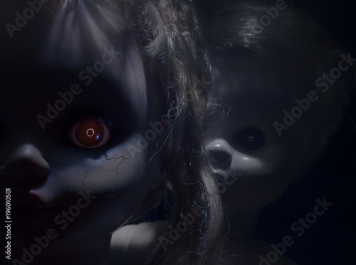 Foto Two creepy faces of scary plastic dolls with fiery eyes, closeup.