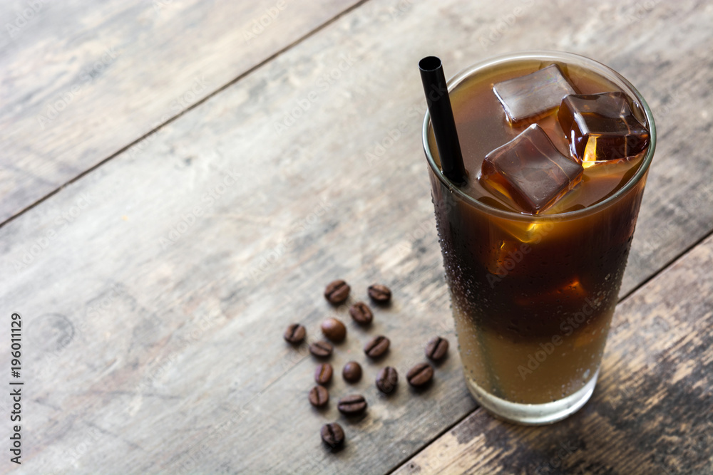 Iced coffee in glass on wooden table. Copyspace Iced coffee in glass on wooden table. Copyspace