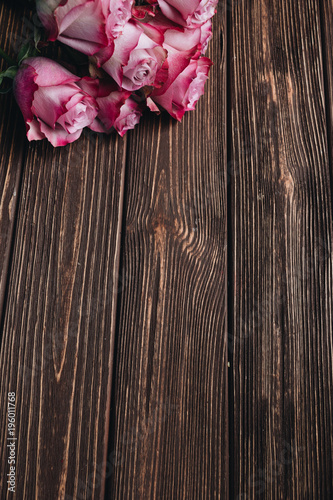 Beautiful pink roses on wooden planks background