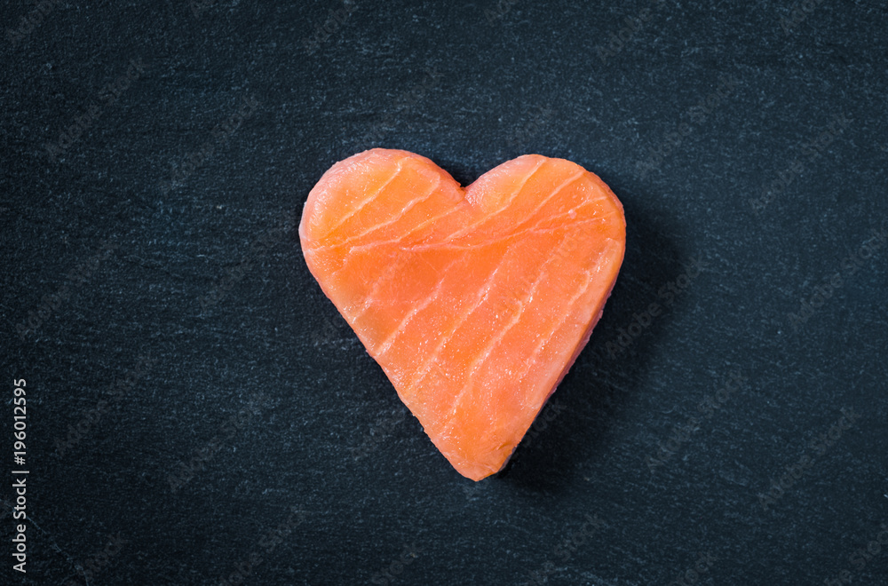 Salmon copy space black slate background. Heart shaped salmon steak. Salmon copy space black slate background. Heart shaped salmon steak.