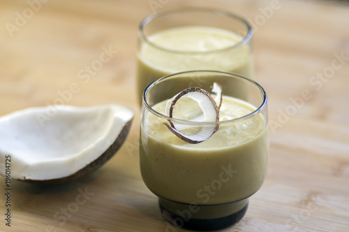 Pineapple smoothie with bananas, oatmeals and coconut milk, decorated with coconut chips