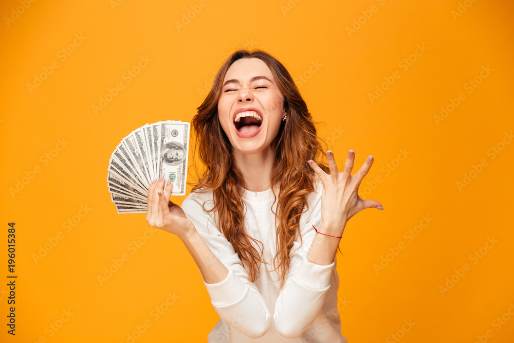 Screaming happy brunette woman in sweater holding money and rejoices Screaming happy brunette woman in sweater holding money and rejoices