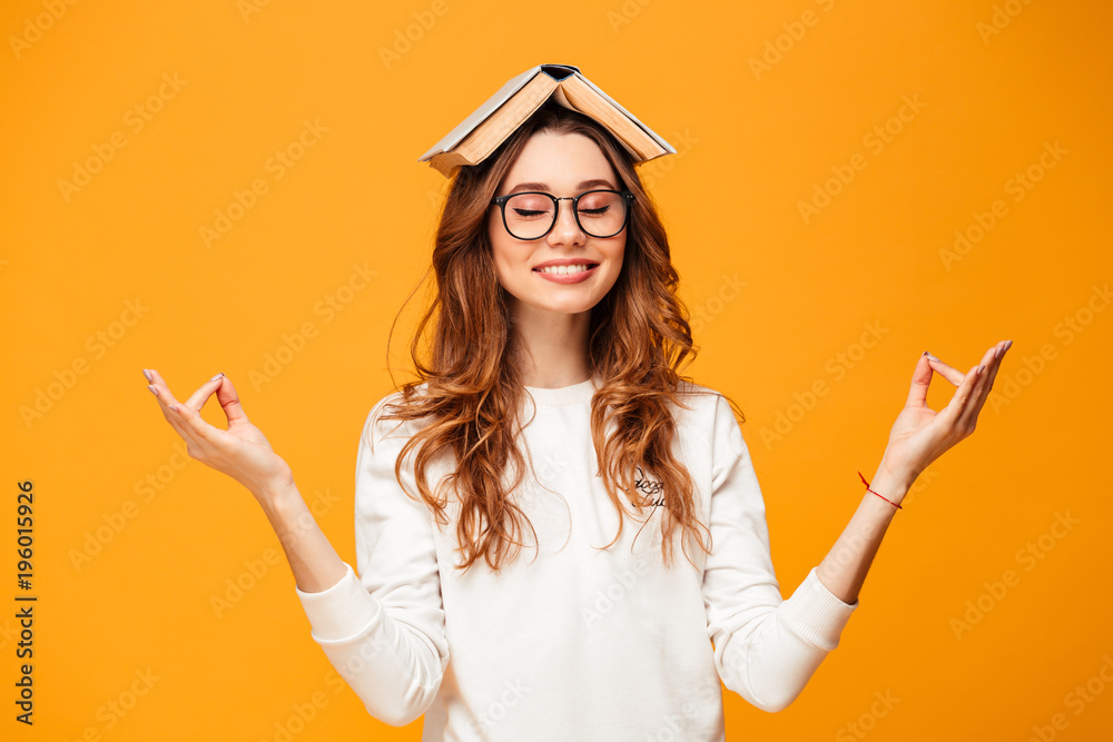 Pleased brunette woman in sweater and eyeglasses meditation - obrazy, fototapety, plakaty 