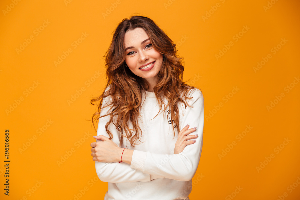 Smiling brunette woman in sweater posing with crossed arms Smiling brunette woman in sweater posing with crossed arms