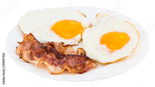 Plate with fried eggs and bacon on white background
