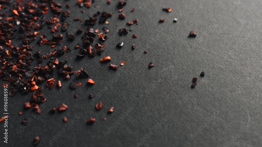 Scattered red spice on black background Scattered red spice on black background