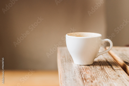 White cup of coffee on wooden table