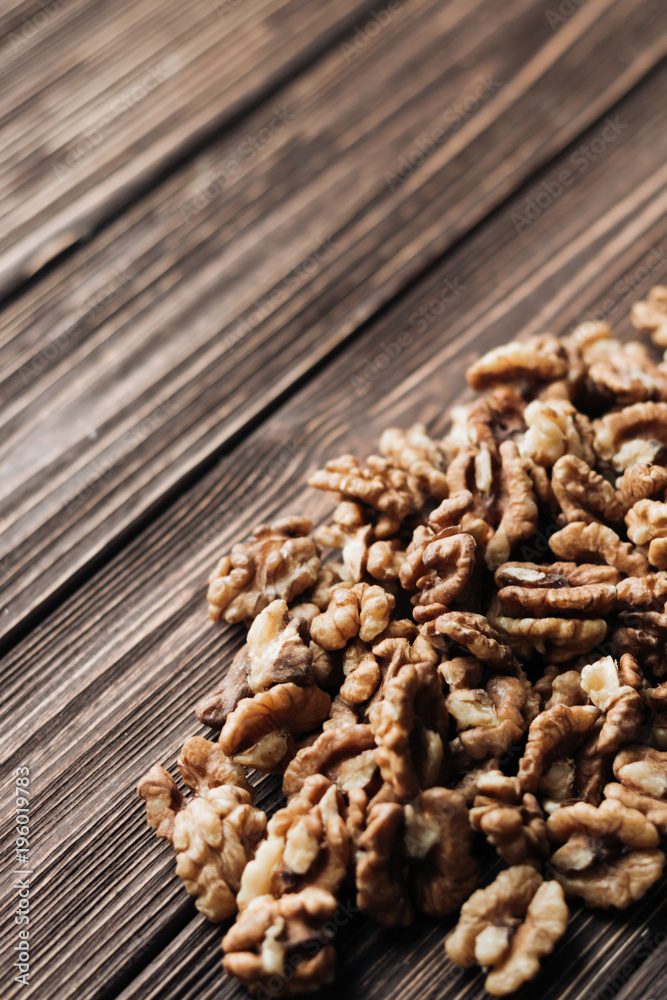 Pile of shelled walnuts on wooden background, healthy eating concept Pile of shelled walnuts on wooden background, healthy eating concept