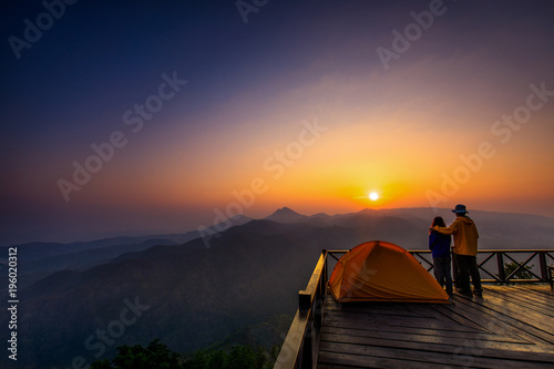 In the morning. Tourists watch the sunrise on a wooden balcony.