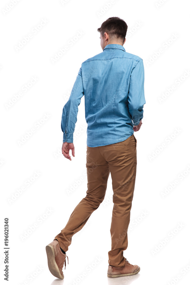back view of a walking casual man looking to side back view of a walking casual man looking to side