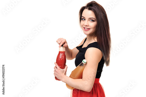 Happy woman comparing two juices isolated on white background. photo