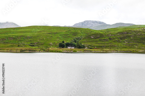 Lonely house on the bank of lake in Ireland
