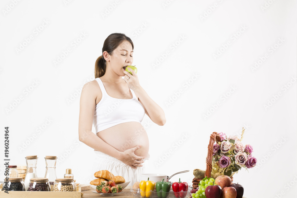 Pregnant women eat apples in the kitchen. Pregnant women eat apples in the kitchen.