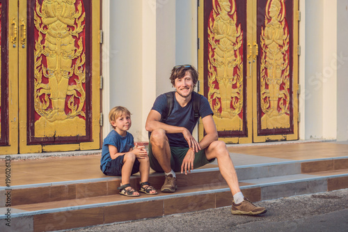 Father and son tourists in Thai temple in Phuket Town Wat Mongkolnimit photo